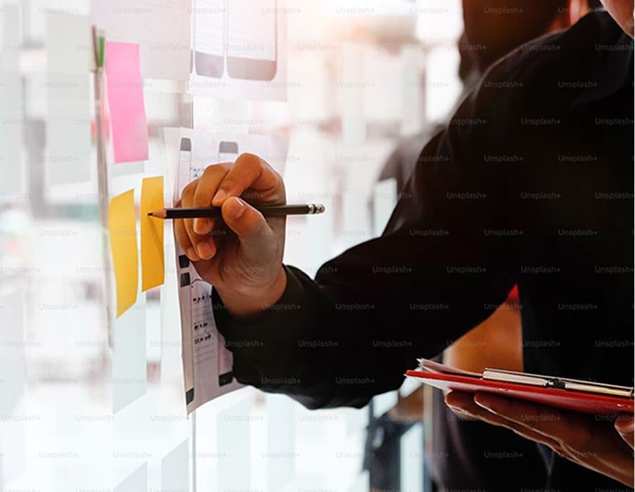 Educator writing on post-its on a wall